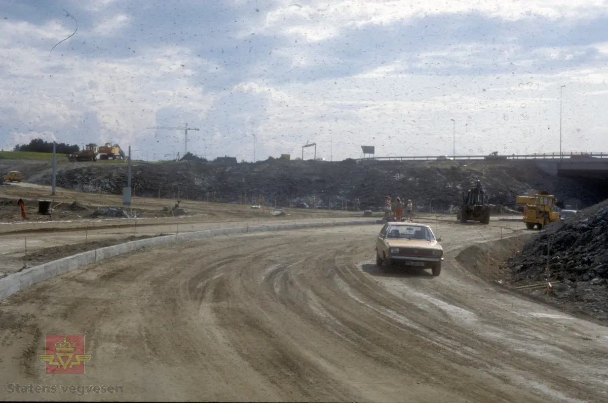 Bygging av ny E-6 mellom Sluppen og Tonstad. Innspurt før åpning av veien. Det jobbes på avkjøring sørfra mot Kolstad (til høyre) / innpåkjørsel fra Sjetnemarka (til venstre). I bakgrunnen E-6 retning sørover.