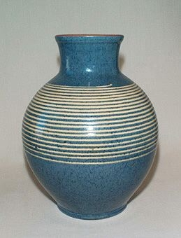 Blå klotformad vas med hals av lergods dekorerad med gul spiral runt om, brun kant upptill och blå insida.