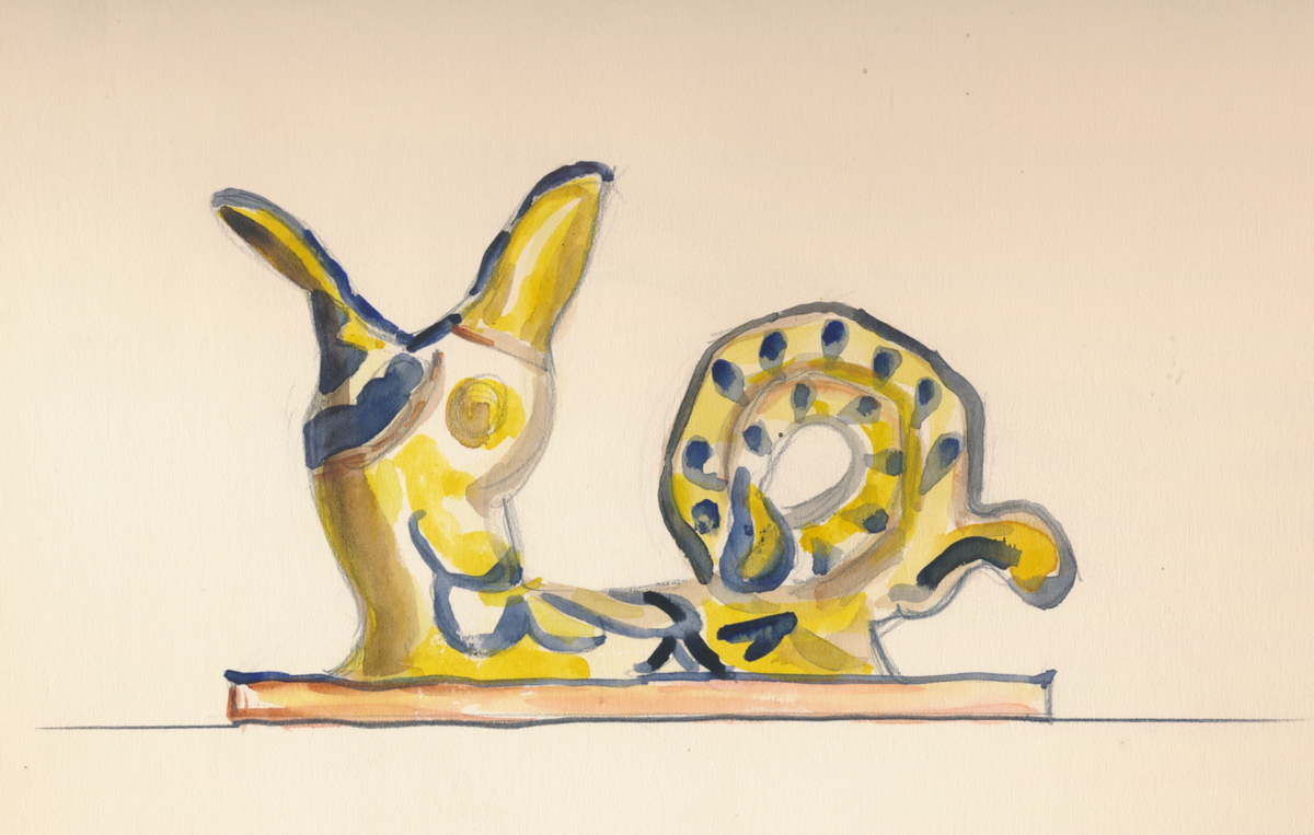 Ljusstake, föreställande ett odjur, av lergods i gul och blå färgsättning.