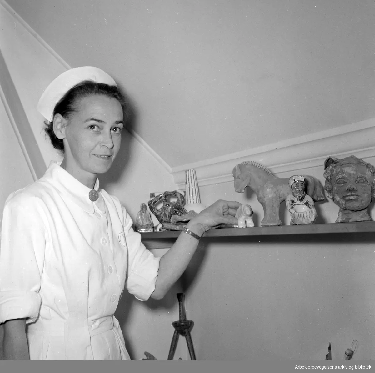 Ullevål sykehus. Psykiatrisk avdeling. Arbeidsterapaut Reidun Skøien med noen av pasientenes keramikkarbeider. Juni 1956