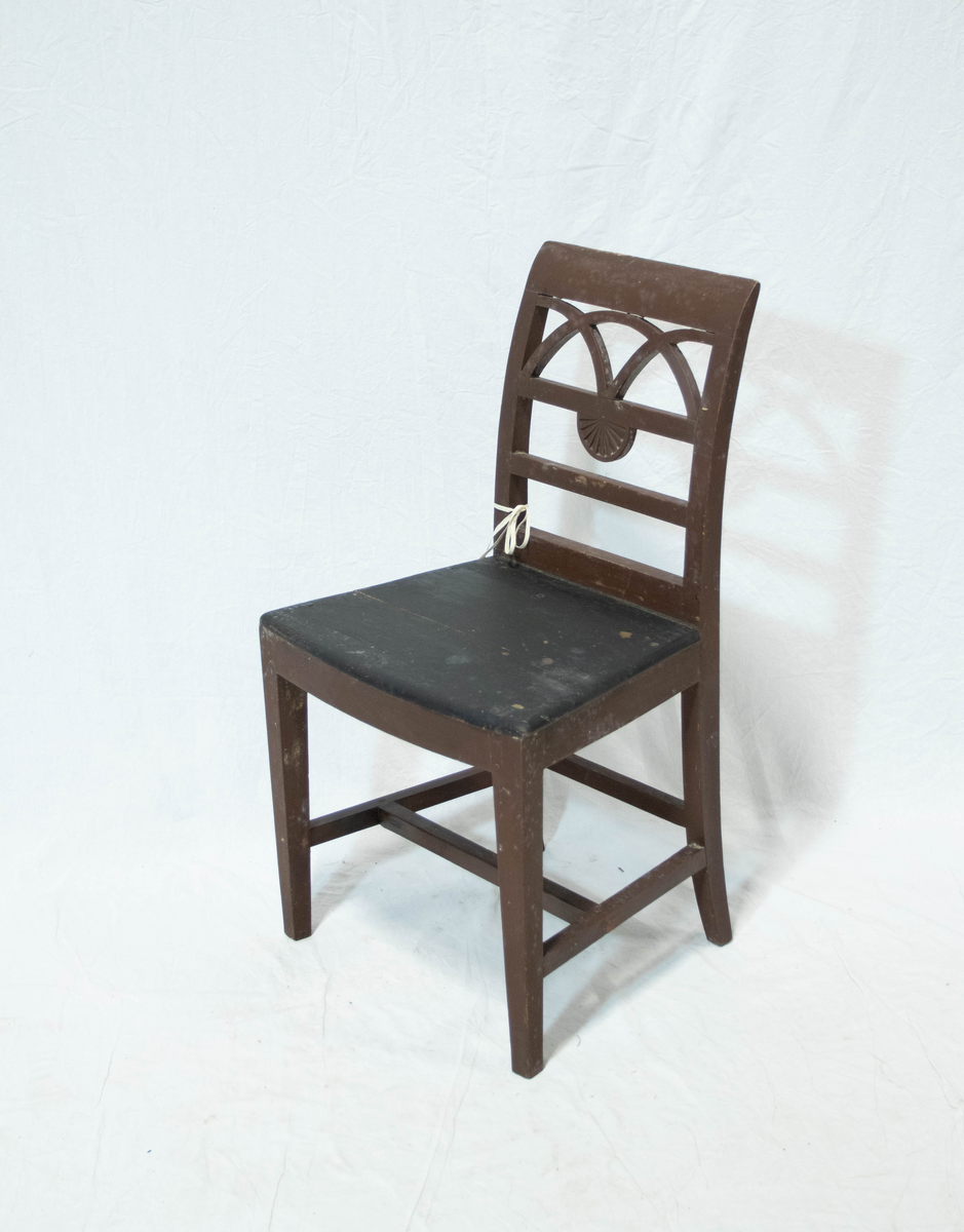 Trestol, hovedsaklig av bjørk men med sete av furu. Stolen har rester etter rødbrun maling. Stolen har rette forben og stramme C-formede akterstavene med firkantet tverrsnitt. Stolen har H-formet sprosse i tilegg til sprosse mellom bakbenene. Setet har buet front og ryggen har tre horisontale tversprosser sammen med et noe bredere skulderbrett. I øverste ryggfelt er det en halvsirkel som skjæres av to kvartsirkler. I midtre ryggfelt et det en halvsirkelformet vifte.