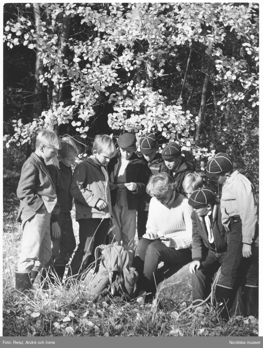 En gruppledare med en grupp pojkar i skogen.