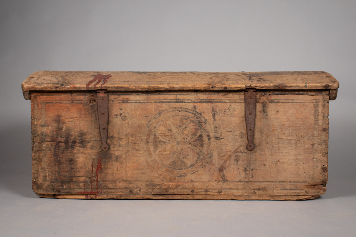 Håndhøvlet kiste i tre med falske jernbeslag og dekorative utskjæringer. 