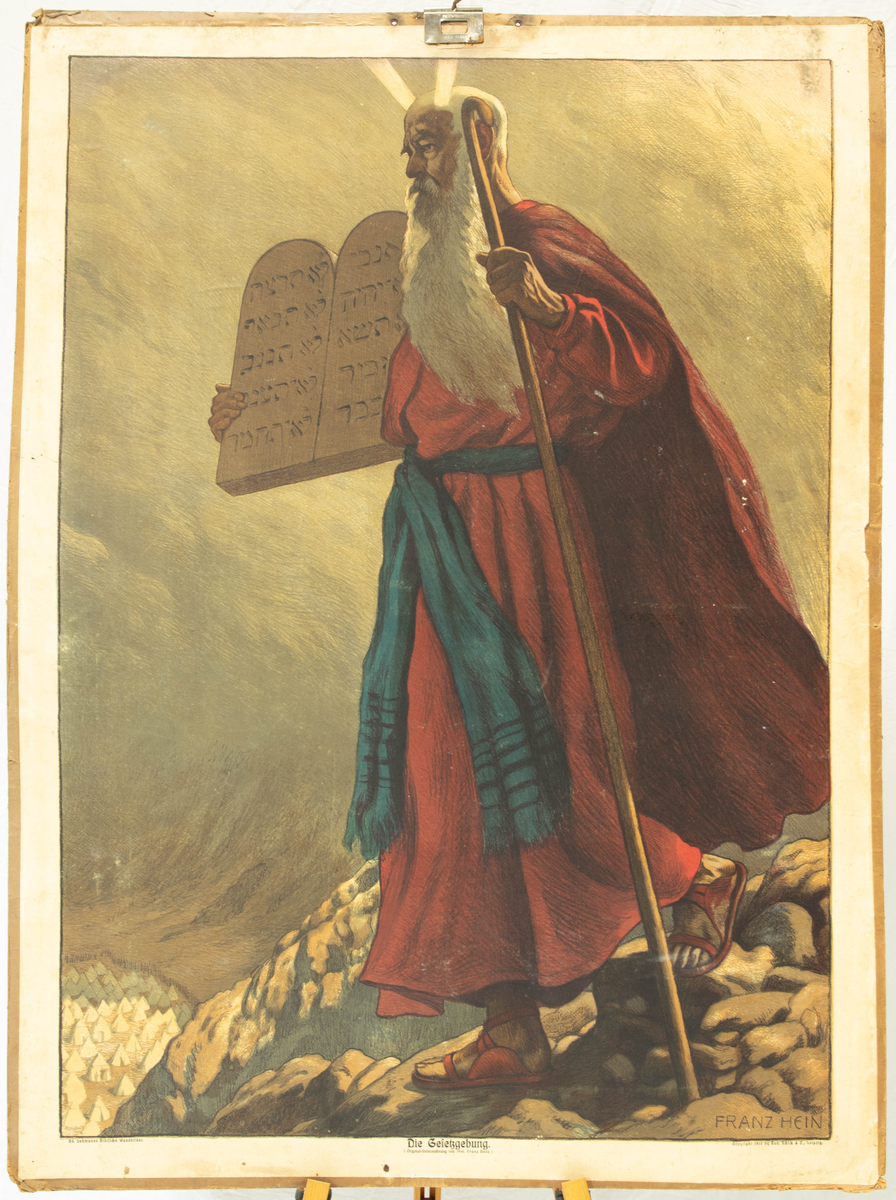 Mann med lyshorn går nedover en knaus bærende en tavle med tegn