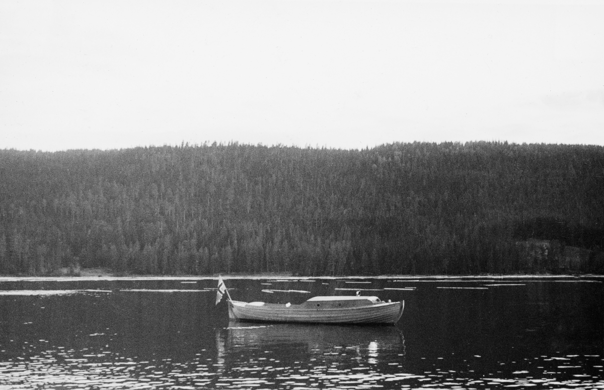 Motorsnekke - klinkbygd, motordrevet trebåt - som antakelig ble brukt som inspeksjonsbåt under tømmerfløtinga på Storsjøen i Rendalen. Bildet skal være tatt fra koieanlegget ved Sjømoen, i den søndre enden av innsjøen.