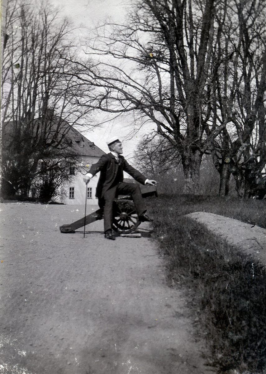 En mann står ved en kanon.
Maarten på Sorenskriverkontoret 1903.
Bilde er fra fotoalbum GM.036887.