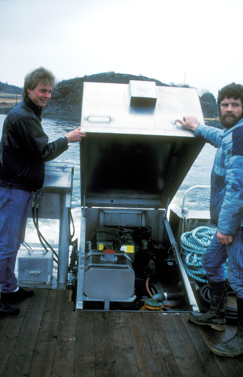 Simo 1988 : To menn løfter opp luka til motorrommet i båten.