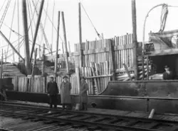 Lastebåt med tømmer, antakelig Sarpsborg havn. Personer er u
