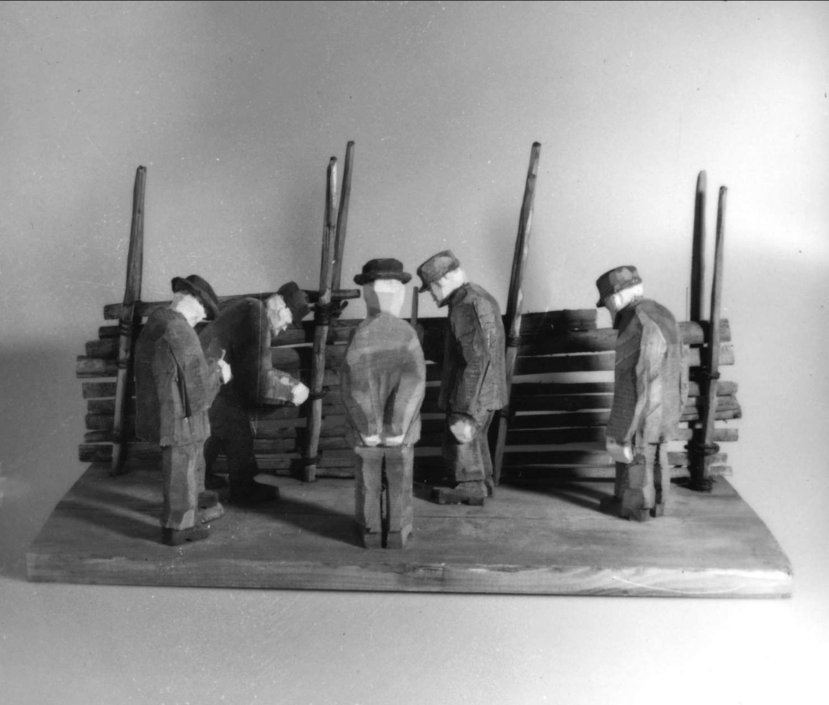 Skulptur av trä. "Gärdsgårdssyn", tillverkad av Hans Lustig. 

Skulpturscenen föreställer fem inspekterande en gärdsgård. Hela gruppen är placerad på en träplatta.