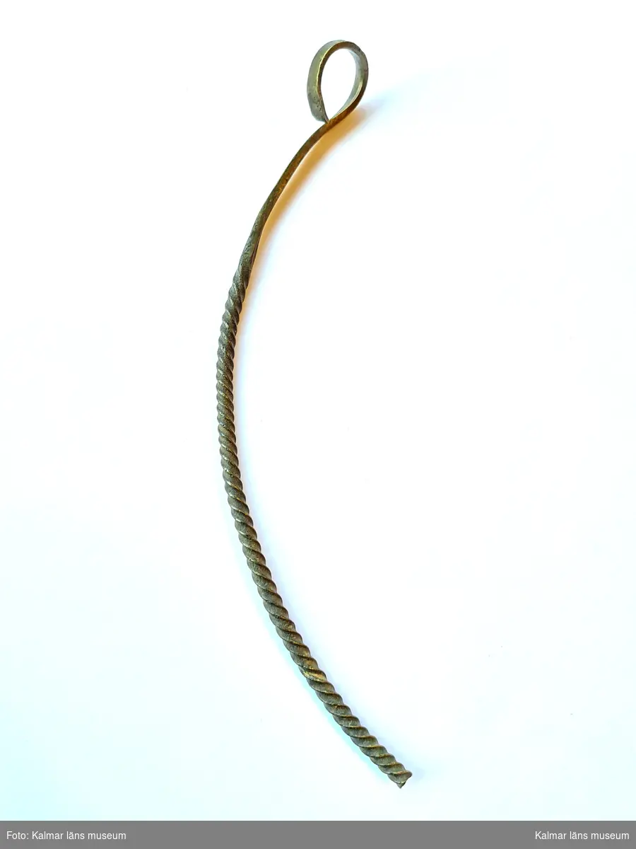 KLM 1065. Halsring, av brons. Fragment av en halsring. Smal enkelvriden ten, mot ändan platt och upprullad i en ögla.
