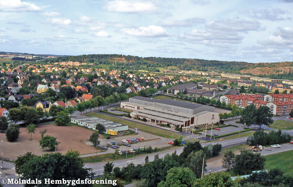 Vy över Toltorpsgatan mot bostadsbebyggelse på Solängen samt idrottshuset och Fässbergsgymnasiet i Mölndal, juli 1992. D 16:28.