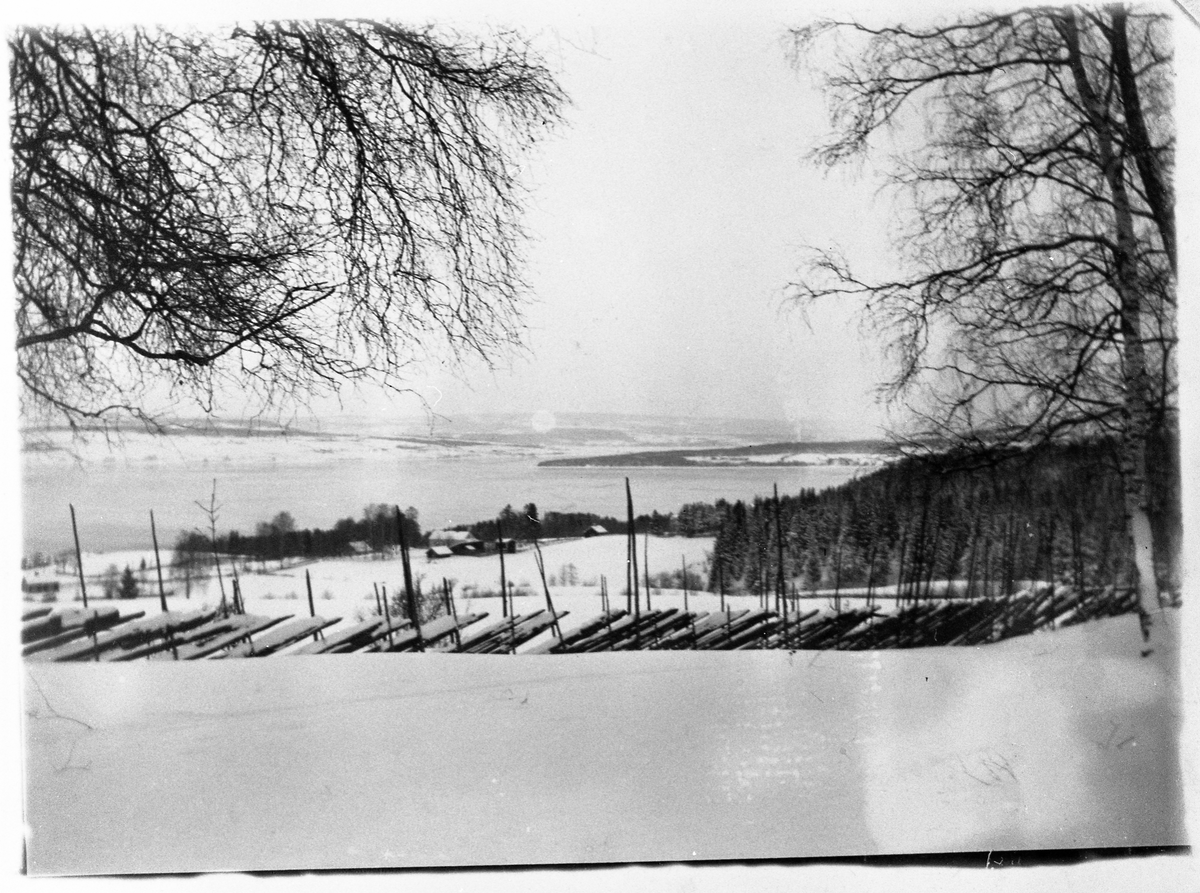Utsiktsbilde tatt fra Evenrud, Kapp i Østre Toten, i retning Nes/Helgøya ca. 1900. I forgrunnen eiendommen "Nøisomhet" der Gustav Raabe, kaptein på Skibladner, bodde.