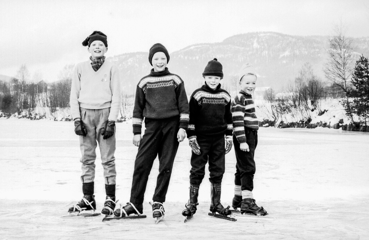 Magne Thidemansen, Thorbjørn Thorkildsen, Yngvar Thorkildsen, Vidar Thidemansen går på skøyter nedenfor Komnes skole.
Skøytene var såkalte "blekkspann" som ble festet til vanlige støvler med "fleskereimer"