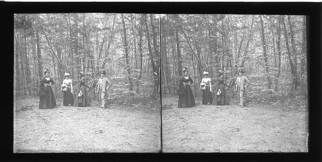 Tre kvinnor och en man framför ett skogsparti. De är möjligen från vänster: Céline Machuron, hennes svärdotter Jeanne Machuron samt fru och herr Lachambre - polarballongen Örnens konstruktör.
Diapositiv, stereoskopisk bild.