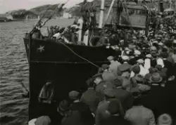 En stor folkemengde og et skip fylt med soldater. Skipet het