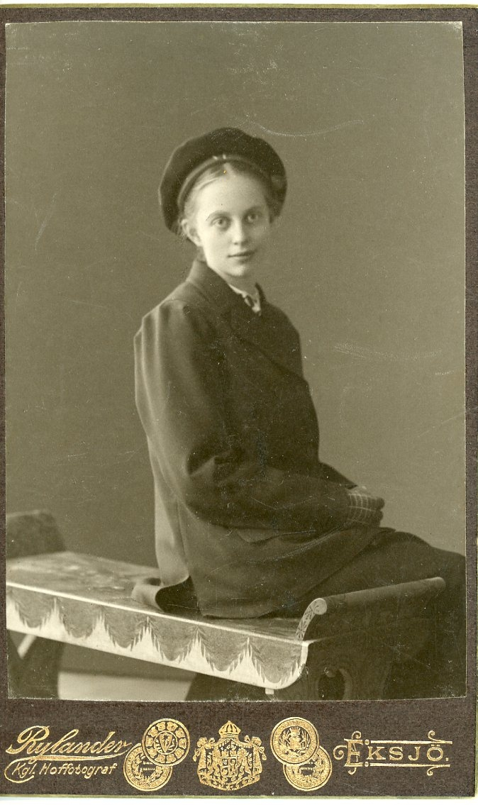 Porträtt av en flicka i tonåren som sitter på en pall.