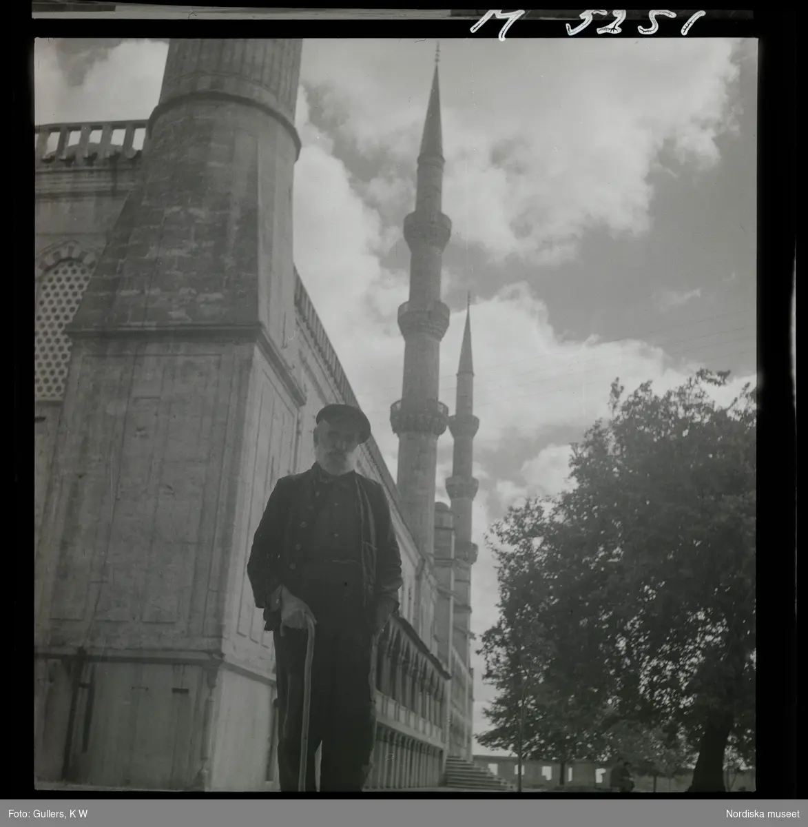 1717/K Istanbul allmänt. En man med käpp framför moské.