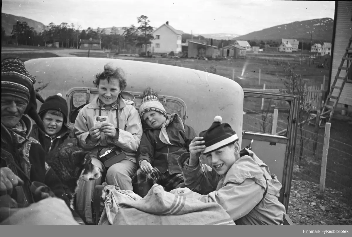 Tur på lasteplan til Kautokeino 1955. En samisk mann som passasjerer (navn ukjent) sammen med Odd Bjørnstad, Gudrun Olsen (kamera henger i halsen), Randi Bjørnstad og Per Møller.