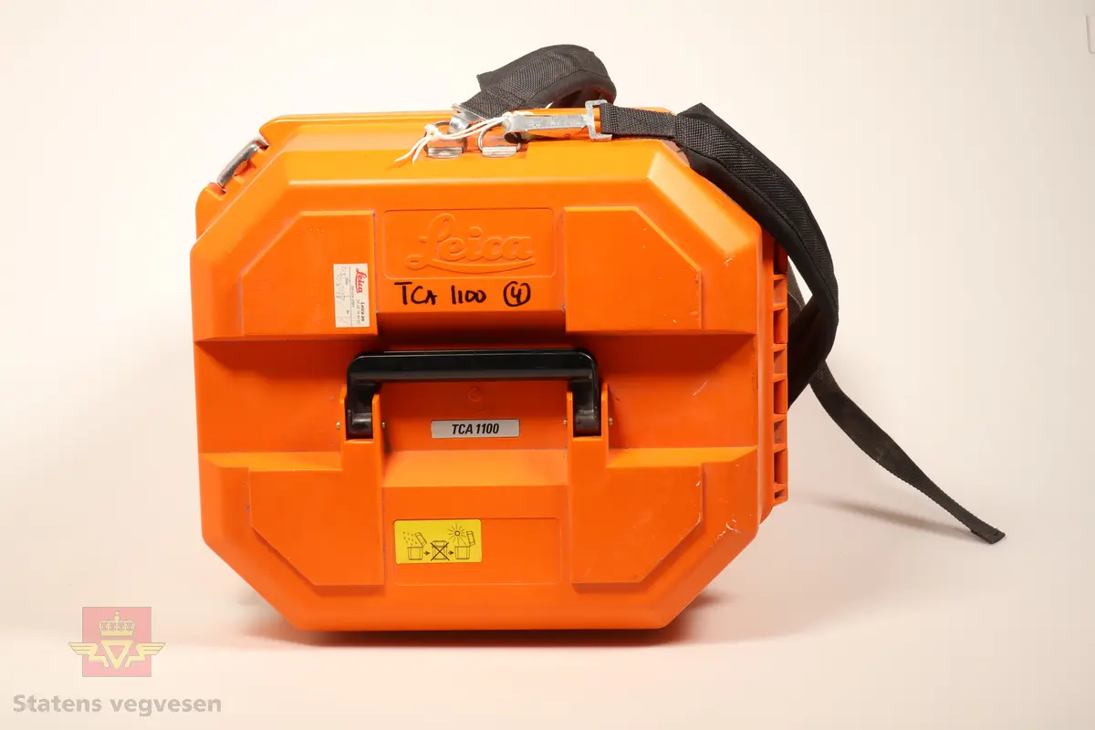 Grønn og svart totalstasjon med oransje koffert. I kofferten er det en totalstasjon oppå en GDF22 Fotplate, regntrekk, instruksjonsmanual, minnekort, mini prismestang med libelle og en LEMO ledning.
