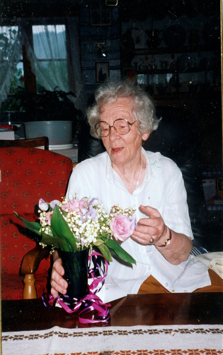 Portrett av Anne Hjuksebø Bakken med bluse og blomster.