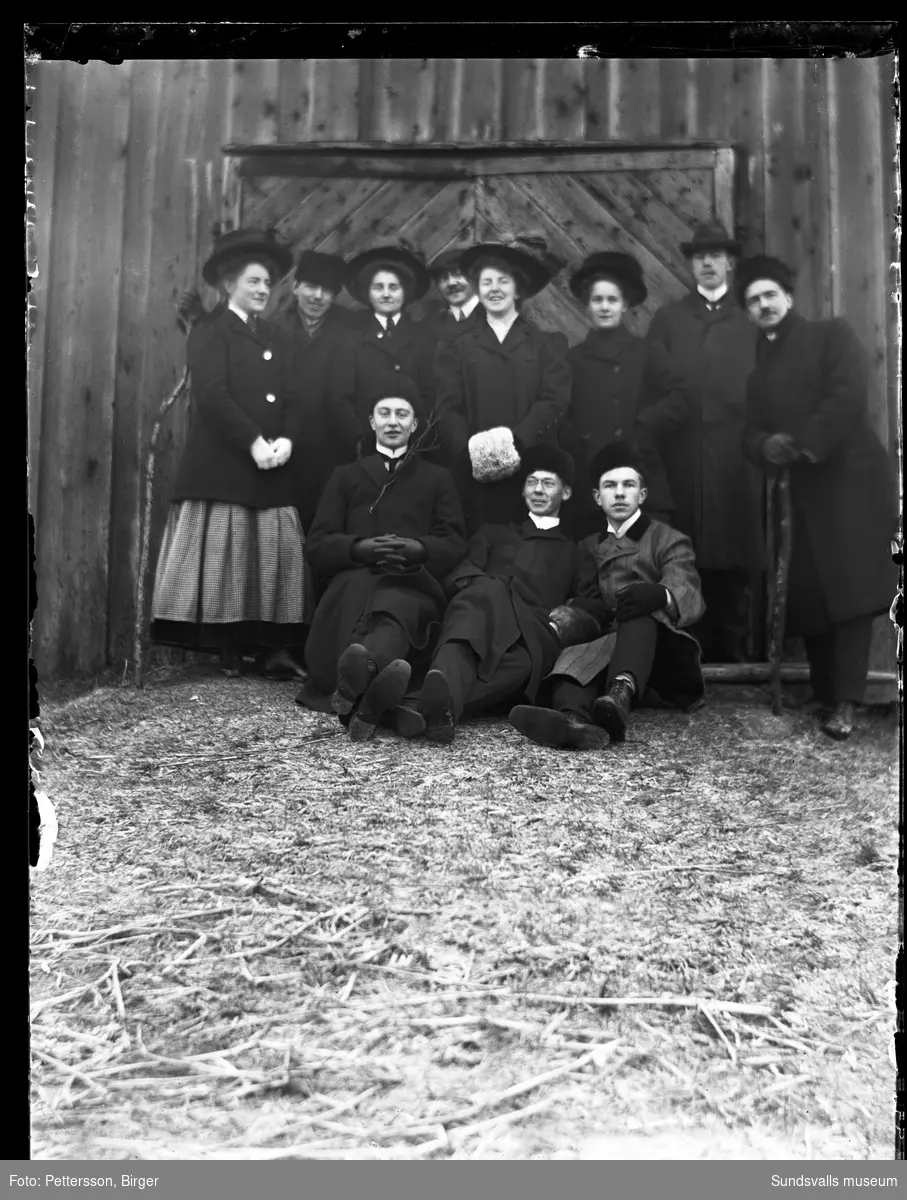 Gruppfoto på en logbrygga med en grupp unga helgdagsklädda kvinnor och män.