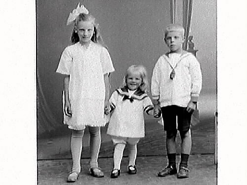 Edvin Anderssons tre barn: dottern Märta och sönerna Evert och lille Bertil som sitter på stolen. Föräldrarna är med på bildnr GB3_17513.