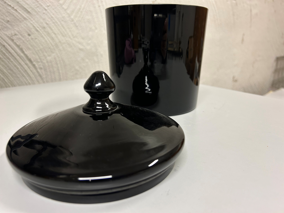 Burk av svart genomfärgat glas, cylinderformad, lock med knopp.