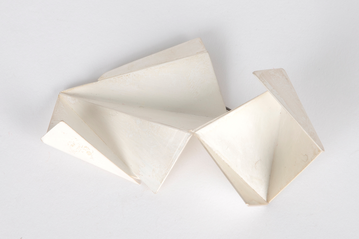 Brosje i sølv. Triangulære sølvplater som er sveiset sammen. Ser ut som origami.