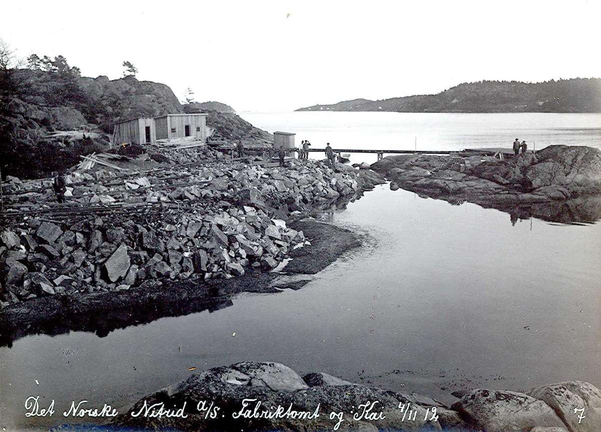 "04/11-1912" Nitriden. Fabrikktomten og anlegg for kai. Anleggsbrakker. Tromøysund og Tromøy til høyre.