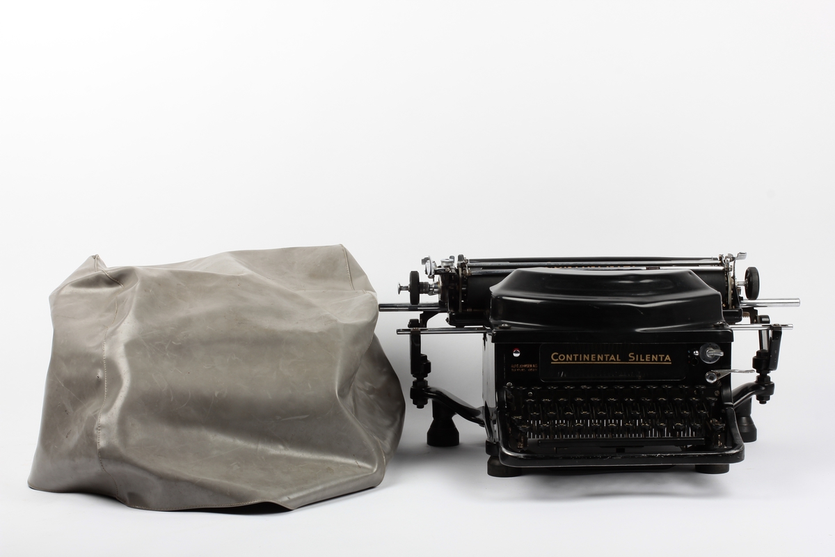 Manuell skrivemaskin med overtrekk av plast. Produsert for å være lydsvak.