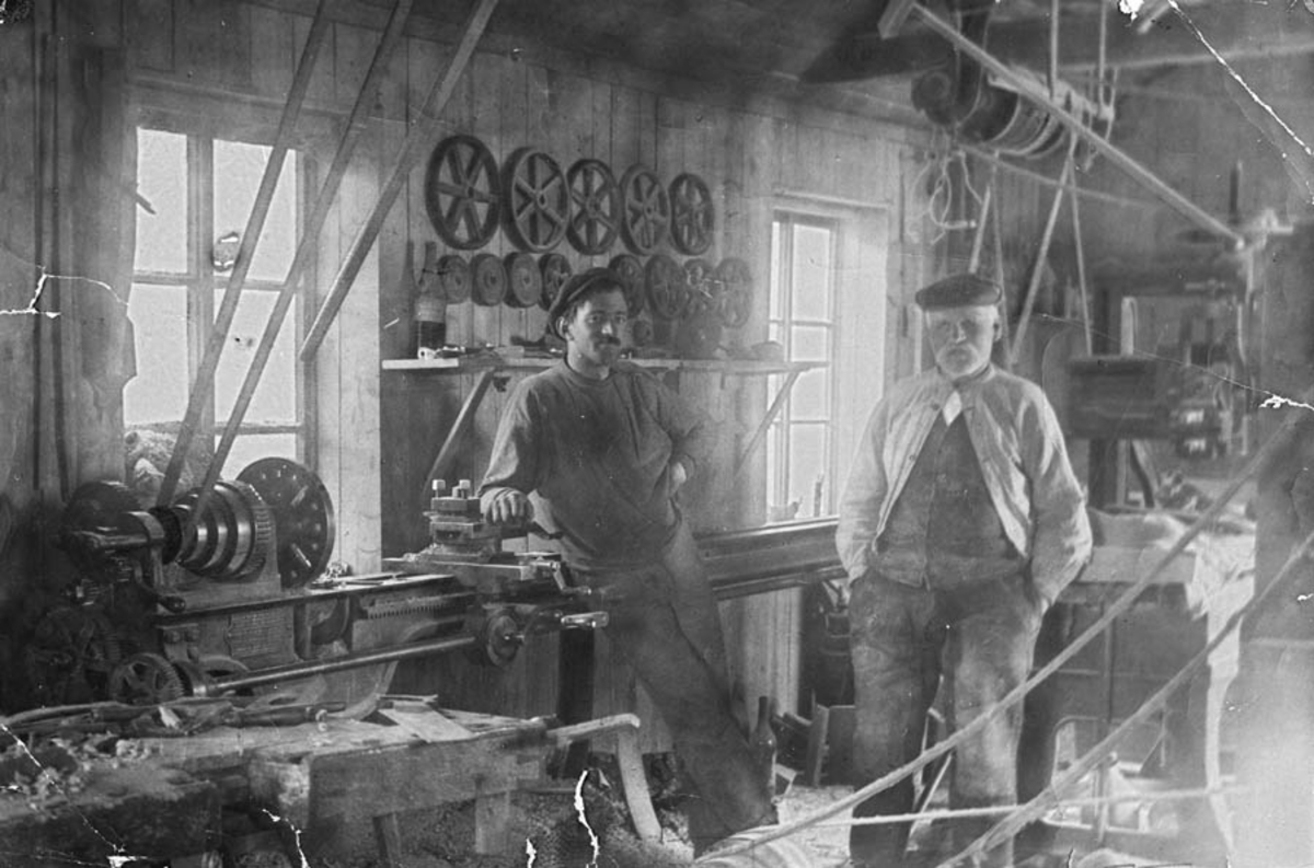 Svartdahl Bruk
Verkstedinteriør med remdrevet metalldreibenk. På veggen et utvalg av drivhjul.
A. Herman Iversen og Martin Olsen Veiby poserer ved maskinen.