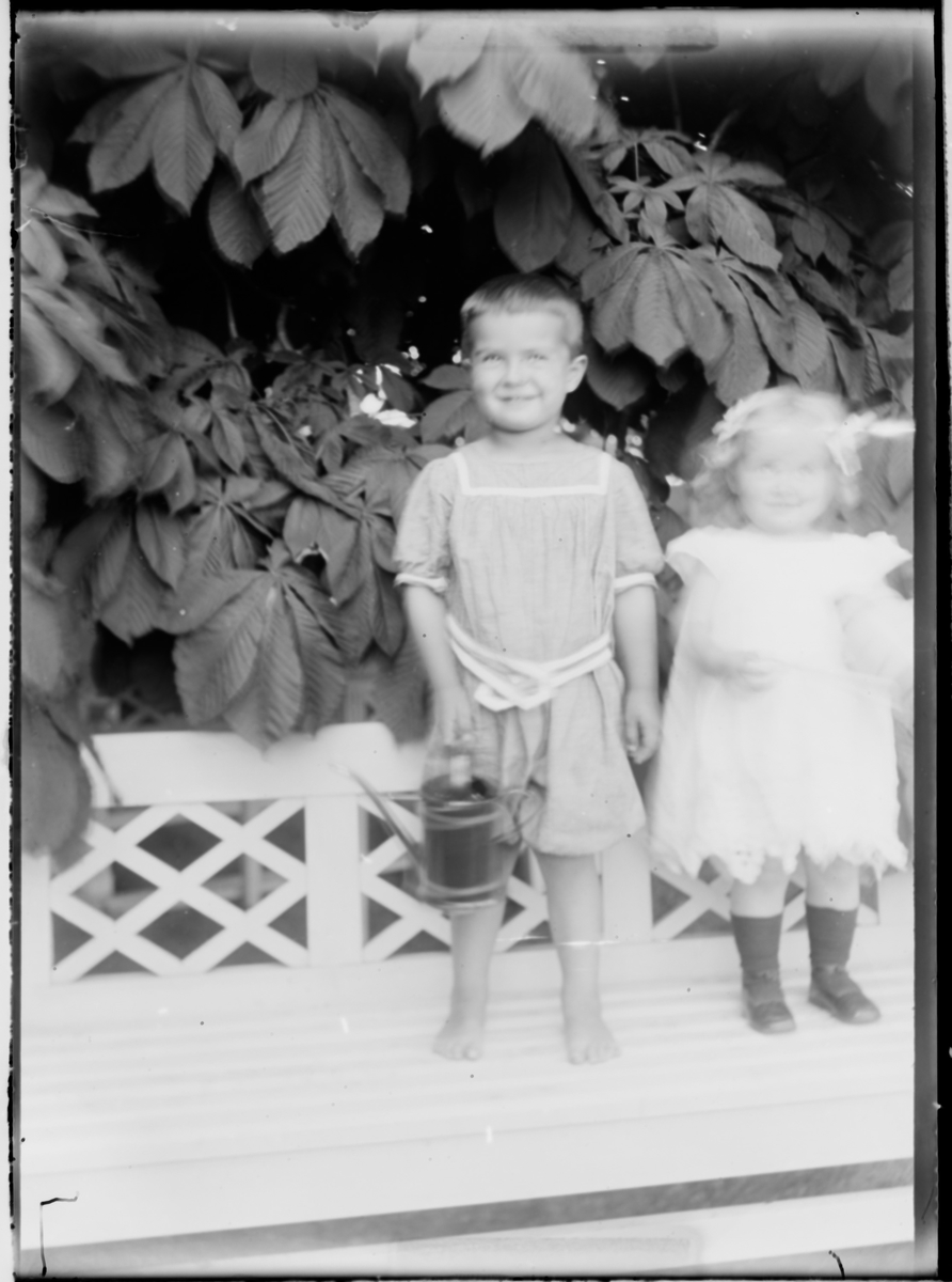 En liten gutt og en jente stående på en benk. Gutten er Wladimir Hansson.