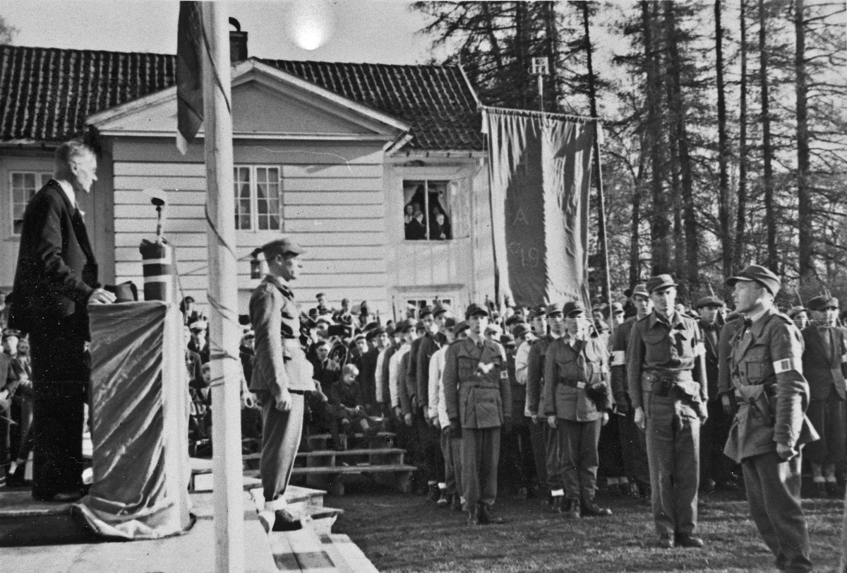 Parade ved Eidsvollbygningen sommeren 1945. Offiser Bertil Bøhnsmoen foran talerstolen.