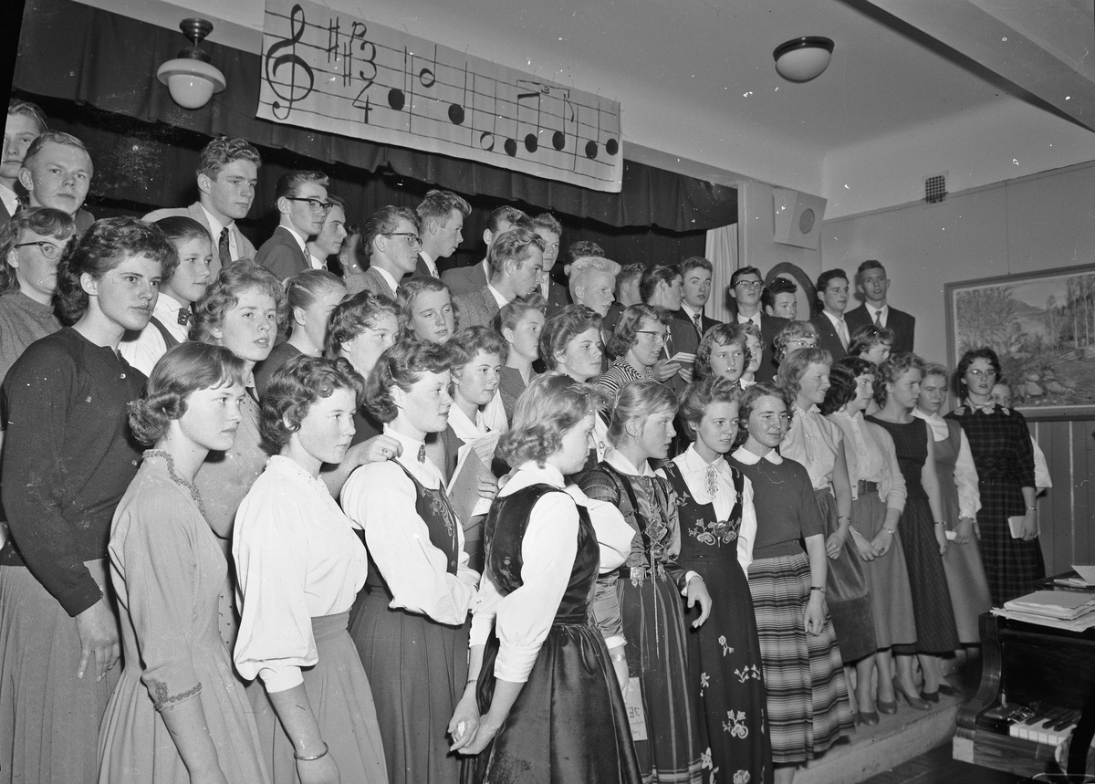 Sangtime/underholdning på gymnaset(?) Lærer Brekke helt til v.. Roald Haugen bak i Mariusgenser.