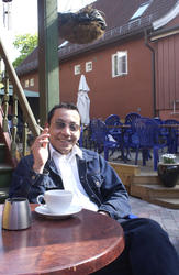 Pubgjest sitter ved et bord med røyk og kaffe i bakgården Mi
