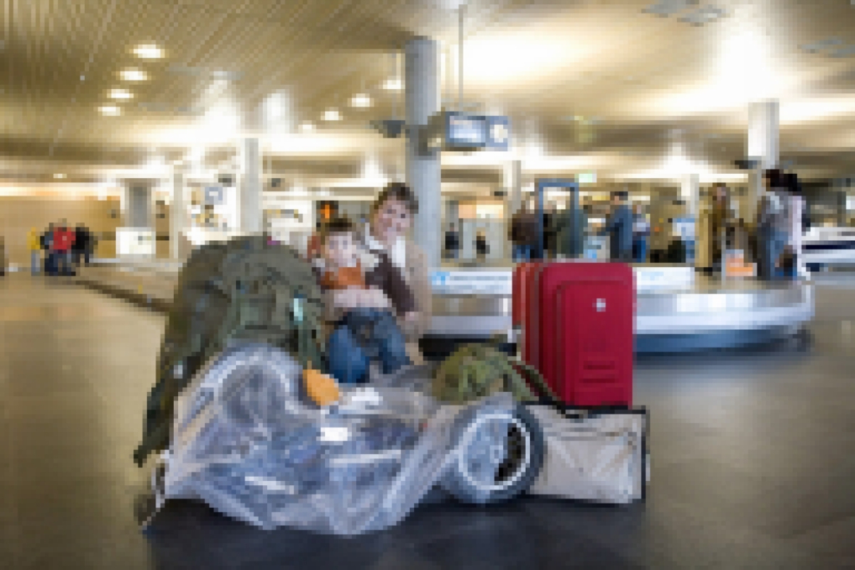 Vesker. Bagasjeutlevering innland. Mor med lite barn og bagasje, deriblant en barnevogn. Fotodokumentasjon i forbindelse med dokumentasjonsprosjekt - Veskeprosjektet 2006 - ved Akershusmuseet/Ullensaker Museum. 