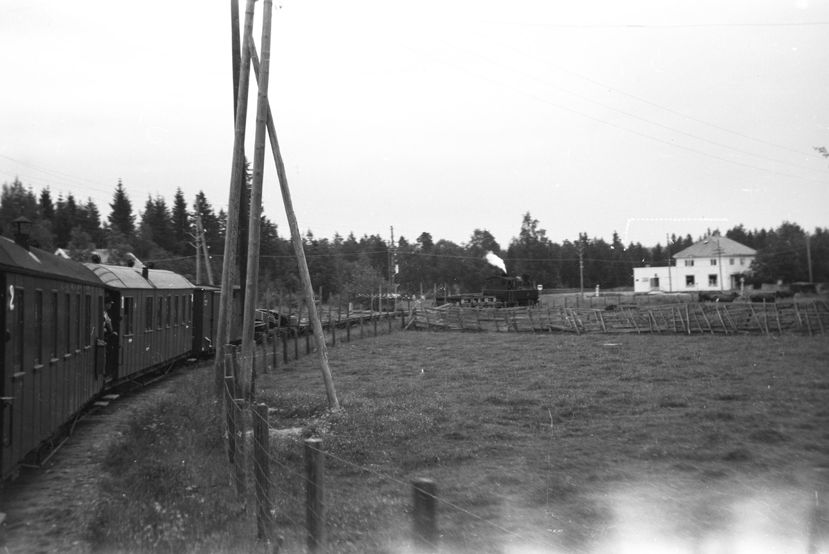 Tog 2051 retning Skulerud,  Ved innkjøringen til Mork stasjon. Mork landhandleri i bakgrunnen.
