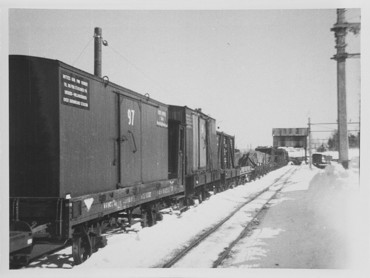 Normalsporede godsvogner med løftekasser og gods som lastes om i portalkranen på Sørumsand.