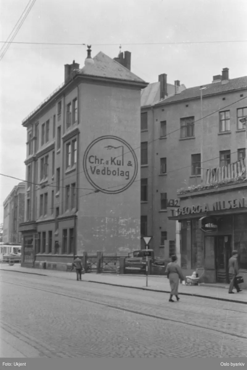 Gatemiljø. Reklame for Christiania Kul - & Vedbolag i Bygdø alle 1 på gavl. Georg A. Nilsen fiskeforretning til høyre i bildet. Frognerveien 2.