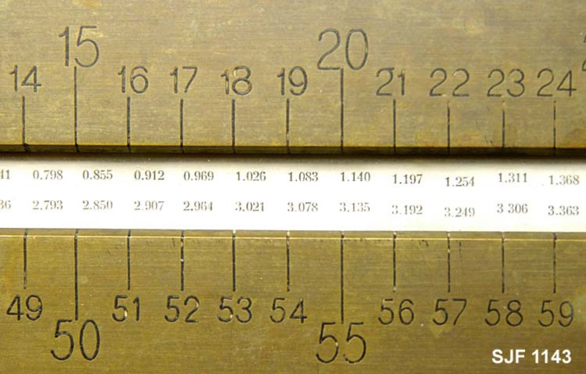 Kubikkberegningsapparat, levert av produsenten F. A. Krog i Skovveien i Kristiania, antakelig tidlig på 1900-tallet.  Apparatet er formet som et rektangulært skrin, utført i eiketre, men med "lokk" av ei messingplate.  Langs midtaksen på dette lokket er det ei lang, smal, rektanuglær spalte med glass under.  Gjennom denne ser vi ned på en tabell.  Tabellen er trykket på en papirrull, som er forankret på to valser nede i skrinet.  Tabellen kan beveges ved hjelp av dreiehjul på skrinets endeflater, to på hver side, ett i hver ende av de nevnte valsene. Ett av hjulene mangler på dette eksemplaret. Lengst til høyre i tabellvinduet finner vi "klassifiseringsinformasjon" - angivelser av stokklengder, diametere og salgsklasser.  Langs den øvrige delen av vinduet kan man lese av kubikkmeterangivelser for fra 1 til 70 stokker med samme dimensjoner og klassespesifikasjon.  Avlesinga skjer fra en tolinjet tabell på den nevnte papirrullen inne i skrinet, og med stokketallesangivelser på lokket - 1-35 stokker på oversida av vinduet og 36-70 stokker på undersida.  Det nevnte emaljerte lokket, som er hvitt med svarte tall og bokstaver, er skrudd fast til toppen av skrinet.  Det er grunn til å tro at valsene med tabellen må være montert før dette ble påsatt.  Skrinet er ellers lagd av høvlet eiketre, og den holdes sammen av de nevnte skruene i lokket og spiker fra botnstykket.  På standflata er det også hengslet en klaff, som kan vippes opp, slik at lokket skrår mot brukeren når apparatet brukes på et bord eller et annet plant underlag.