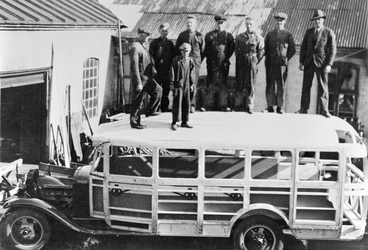 Gruppe arbeidere oppstillt på taket av buss, utendørs ved Hymas A/S, Brumunddal Mekaniske Verksted. Nr. 2 fra høyre : Johannes Løvberg f 15.03.1901 i Furnes.