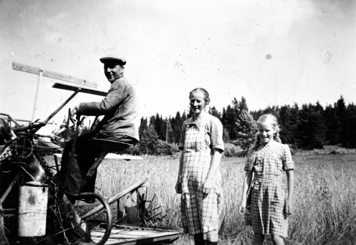 Skuronn på Trosterud, Helgøya. Einar Monsbakken (1902-1985) på selvbinder. Gudrun Elise Monsbakken (1909-1977), Astrid Monsbakken f.1929.