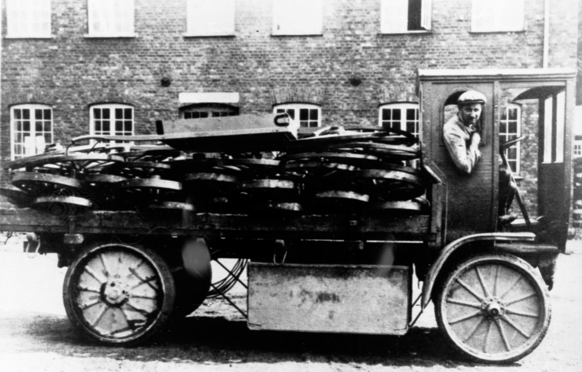 Lastebil med transport av kjerrehjul på Moelven Brug, Ringsaker. Elektrisk lastebil, Walter 1918-1920. En av brugets første biler, for transport av kjerrehjul fra fabrikken til jernbanestasjonen.