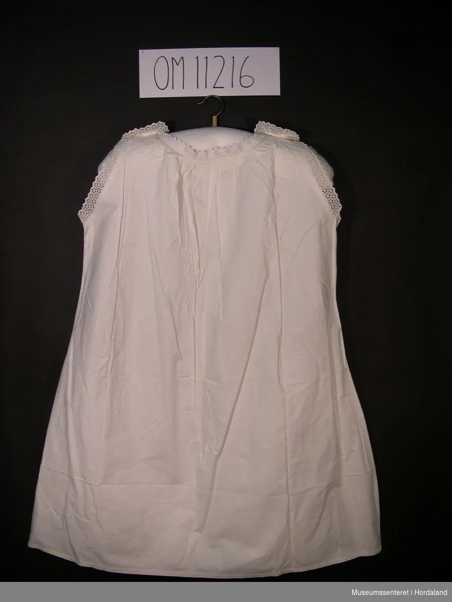 Form: ermelaus nattkjole med knapping på skuldrane og engelsk broderi på brystet og rundt ermer og hals
