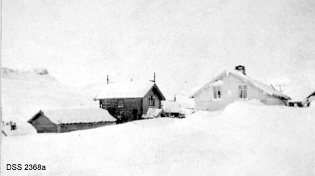 Haukeliseter fjellstue.  Seks vinteropptak, antakelig fra tida like før 1900.  A. Våningshus i djupsnø, en panelt og kvitmalt bygning til høgre, en uthusbygning og et våningshus i drakestil til venstre for dette.  B.  Uthus og våningshus i drakestil, mann med hund foran drakestilhuset.  C.  Våningshus med drakestilpreg, der særlig en toetasjes fløy til høyre i bildet har lånt trekk fra stabbur og loft i Telemark og Numedal.  D. Panelt og kvitmalt våningshus i en etasje, men med rom på loftet.  Snøen står om lag midt på veggen på forsida av huset, nestet opp til raftet på baksida.  En mann bærer noe mot inngangen.  E.  Bryggerhusliknende bygning med torvtak.  En mann ved langveggen og en i døra.  F.  11 personer foran inngangen til den kvite bygningen på fjellstua. Reinsdyrgevir over døra. 