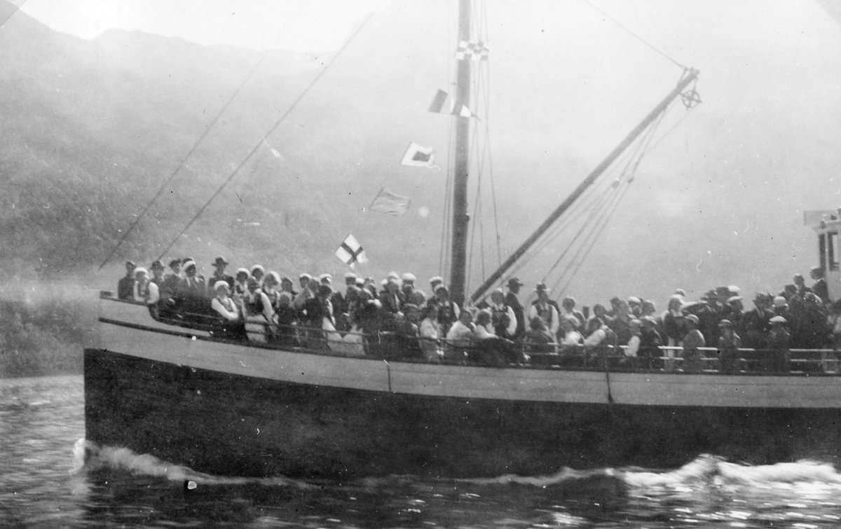 Mennesker ombord i ein båt på veg til Nå
