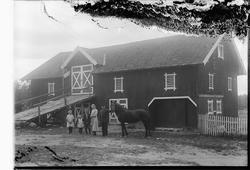 FEM PERSONER OG EN HEST FORAN EN LÅVE, UKJENT GARD.
