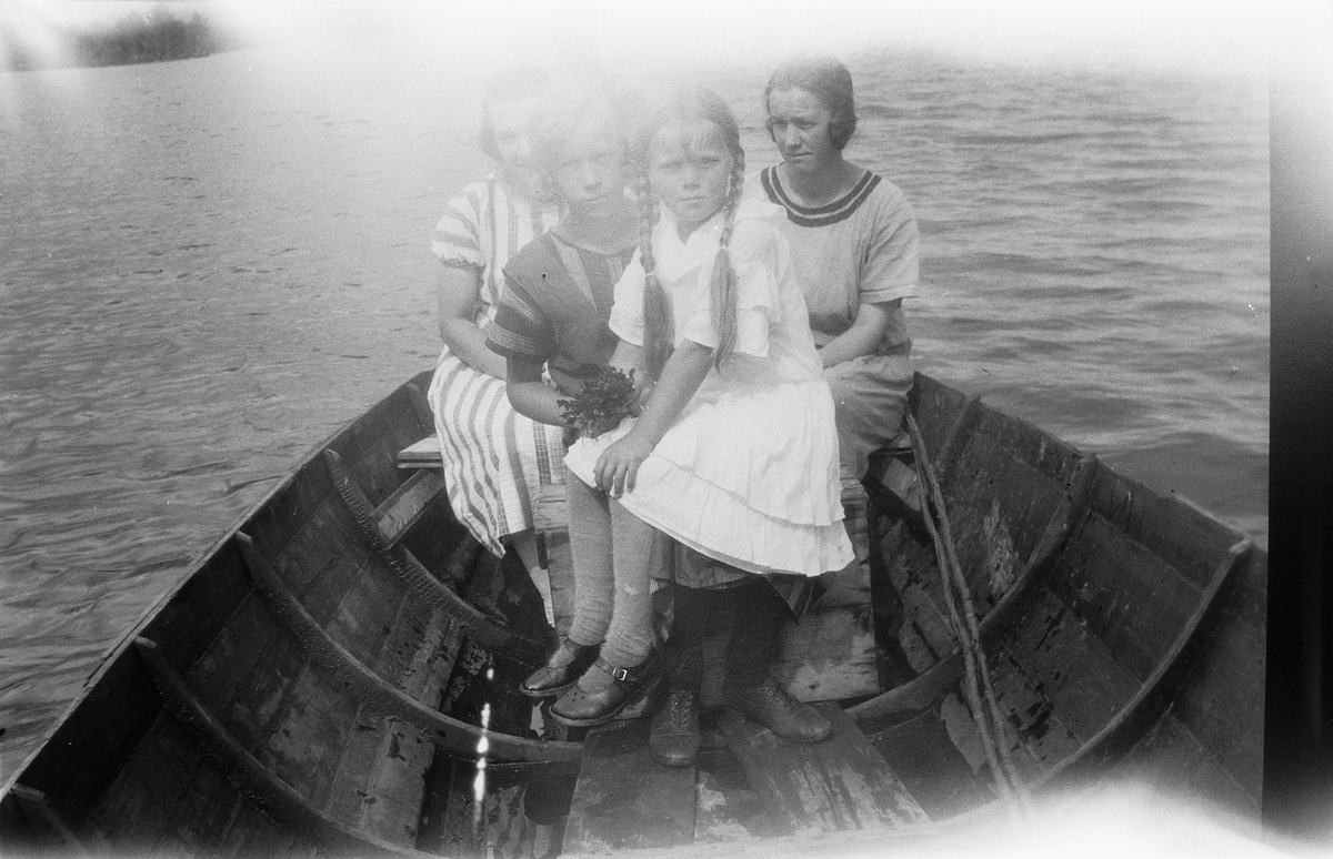 Fire jenter i en robåt. 