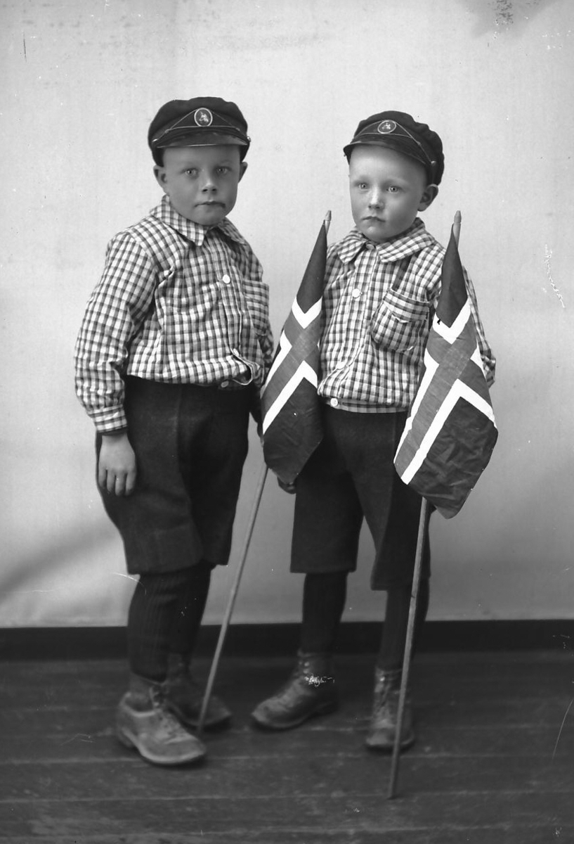 Tvillinger i kortbukser og ullstrømper, med flagg. 