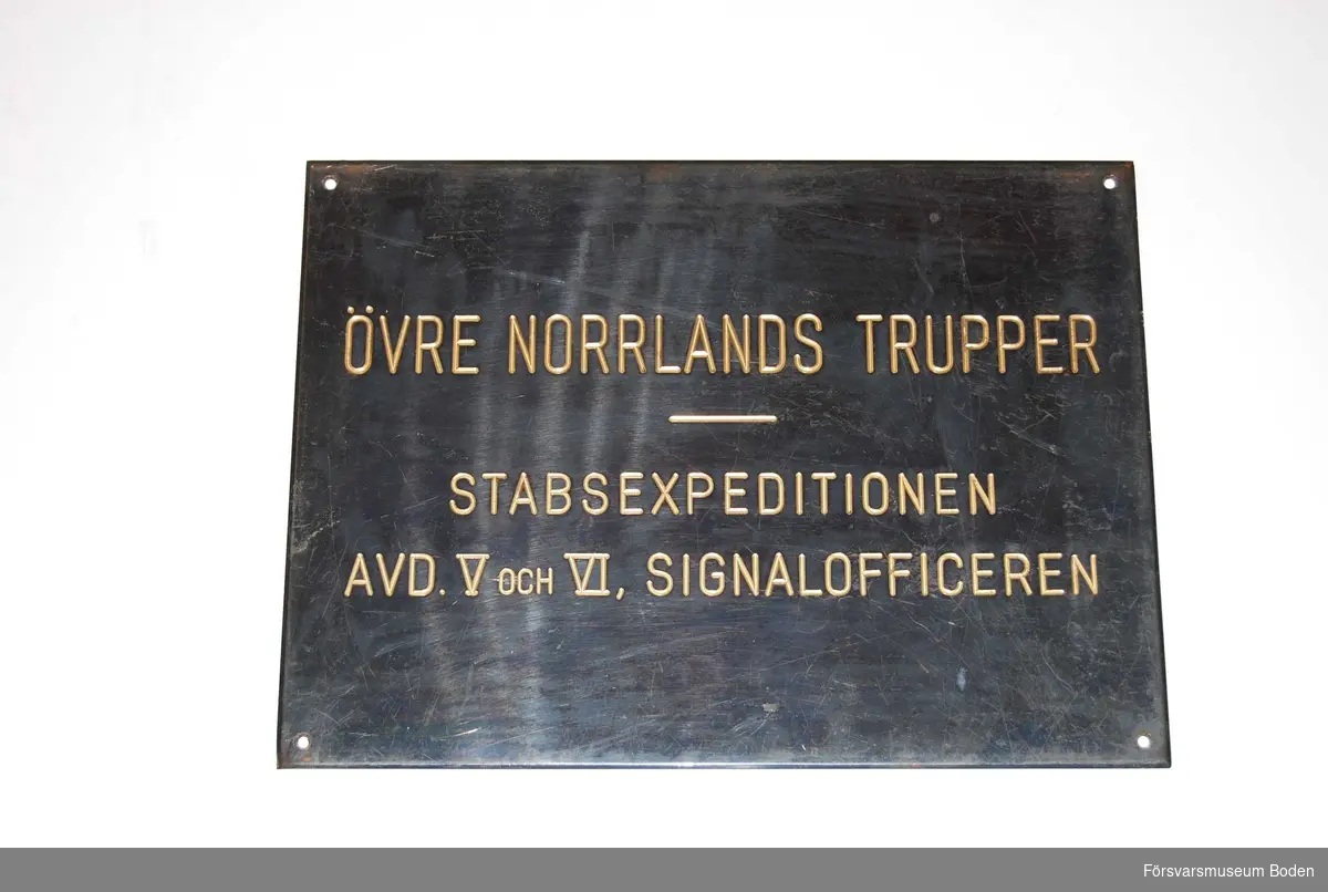 Svartemaljerad plåt. Bör vara från tiden 1928-1942 då benämningen Övre Norrlands trupper användes. Den ersattes sedan med VI. militärområdet.
